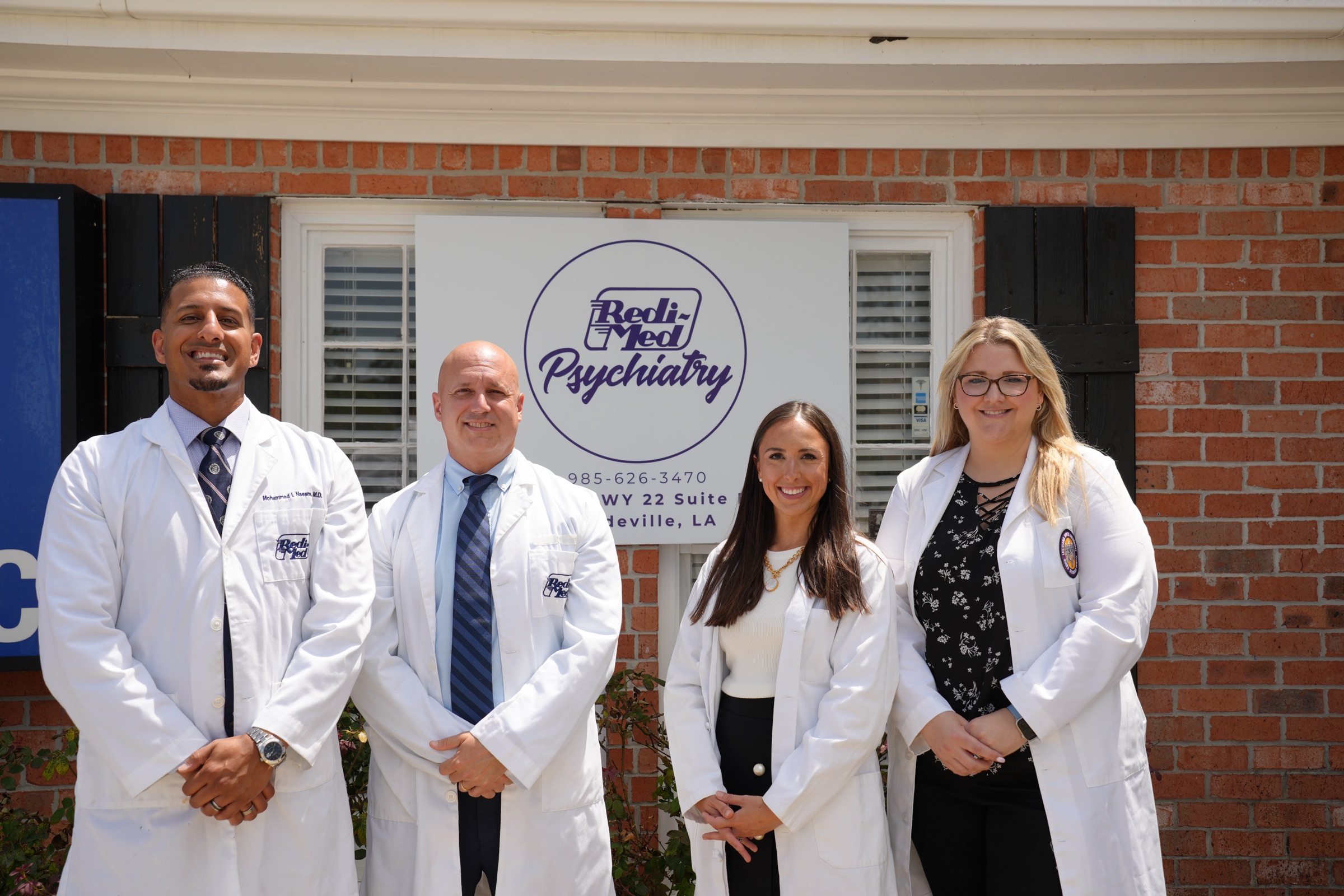 Redi-Med Psychiatry providers — Dr. Naeem, Joel O'Connor, Olivia Esquerre, and Lindsey Kappes — outside the Mandeville office